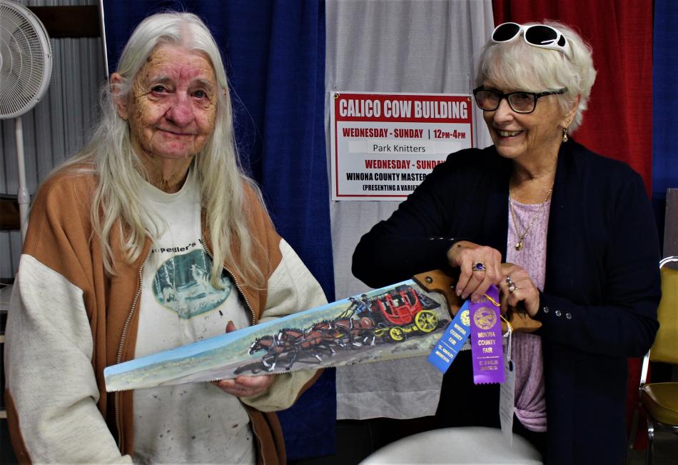 Winona County Fair Official Ruth Melbo Congratulating Alice on her Grand Champion Wells Fargo Stagecoach Saw Painting. (July, 2021) 